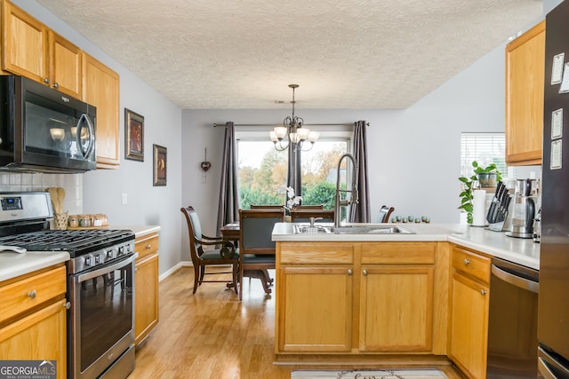 kitchen featuring light wood-type flooring, a chandelier, a textured ceiling, sink, and stainless steel appliances