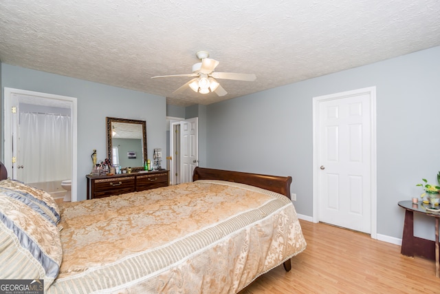 bedroom with ceiling fan, a textured ceiling, light wood-type flooring, and ensuite bathroom