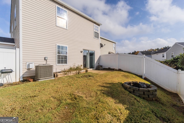 back of house with a lawn and central air condition unit