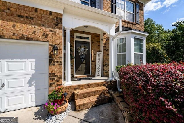 view of exterior entry with covered porch and a garage