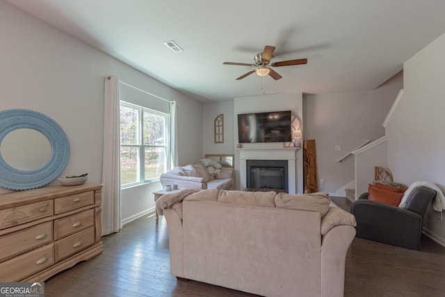 living room with ceiling fan and dark hardwood / wood-style flooring