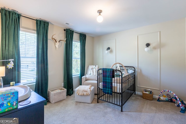 bedroom with a crib and light colored carpet