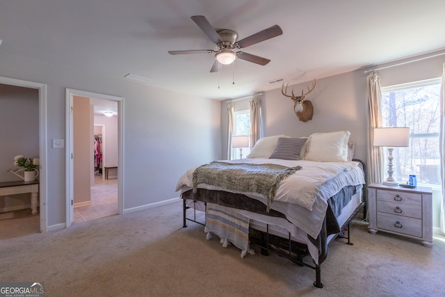 bedroom featuring ceiling fan, light colored carpet, and multiple windows