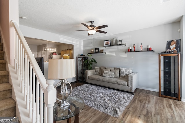 living room featuring a textured ceiling, ceiling fan, and hardwood / wood-style flooring