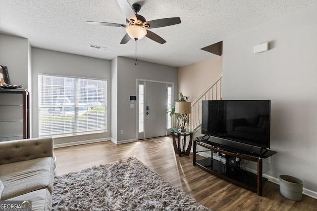 living room featuring ceiling fan, a textured ceiling, and hardwood / wood-style floors