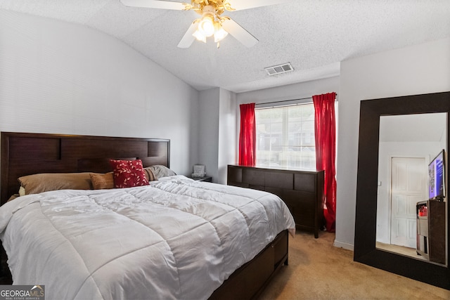 carpeted bedroom featuring ceiling fan, a textured ceiling, and vaulted ceiling