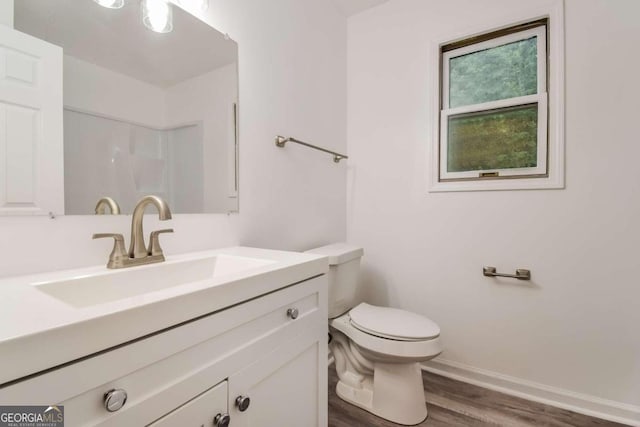 bathroom with vanity, toilet, and hardwood / wood-style flooring