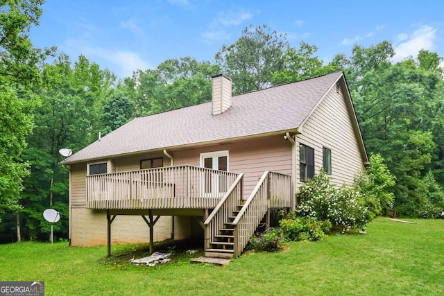 rear view of house featuring a lawn and a deck