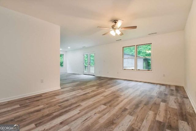 unfurnished room with ceiling fan, french doors, and hardwood / wood-style floors