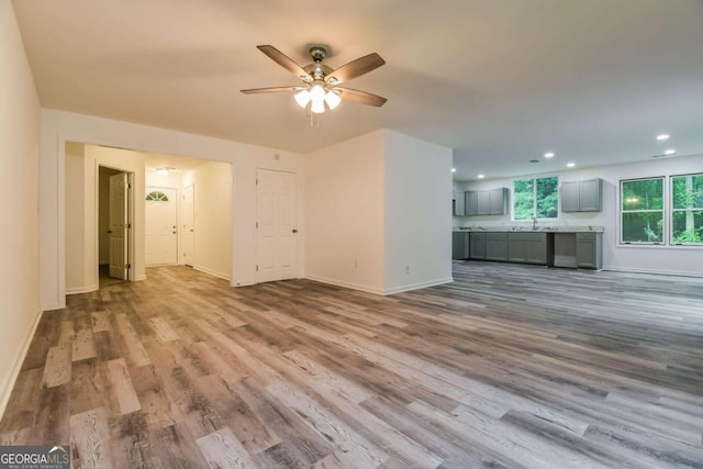 unfurnished living room with ceiling fan and light hardwood / wood-style flooring