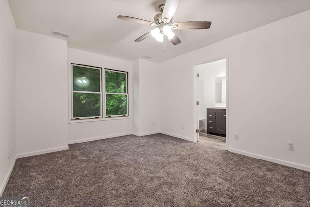 unfurnished bedroom featuring ceiling fan, connected bathroom, and dark carpet