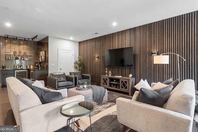 living room with bar, beverage cooler, and track lighting