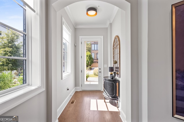 entryway featuring hardwood / wood-style flooring, crown molding, and a wealth of natural light