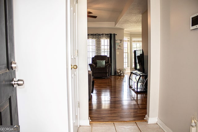 hallway with a textured ceiling and light hardwood / wood-style floors