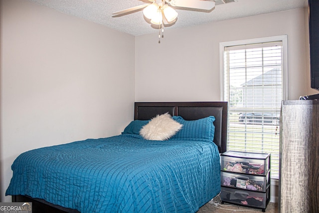 carpeted bedroom with a textured ceiling and ceiling fan