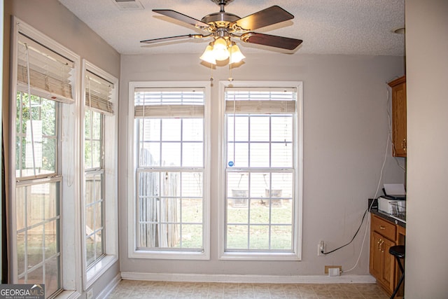 interior space with ceiling fan and a textured ceiling