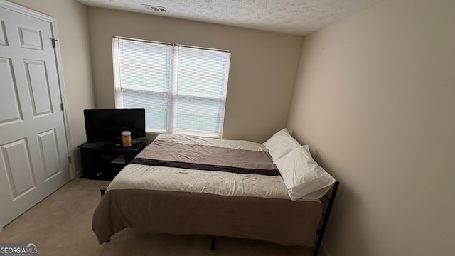 carpeted bedroom with a textured ceiling