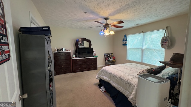 carpeted bedroom with ceiling fan and a textured ceiling