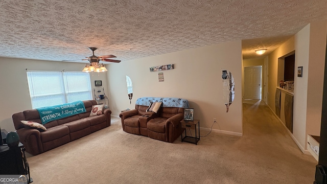 carpeted living room featuring a textured ceiling and ceiling fan