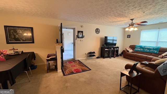 living room with ceiling fan, a textured ceiling, and carpet