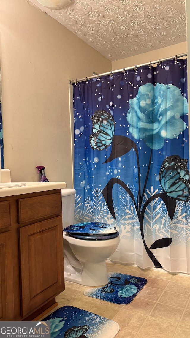 bathroom with a textured ceiling, vanity, toilet, and a shower with shower curtain