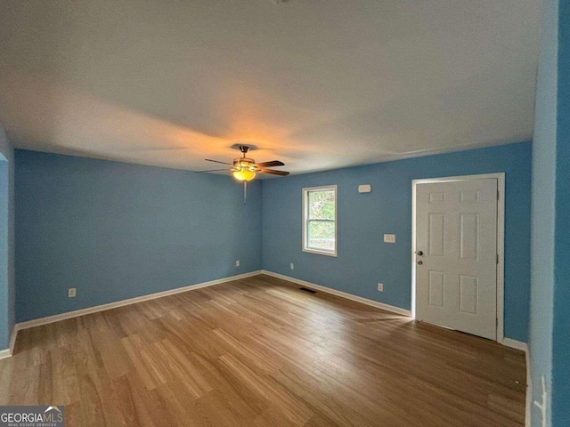 empty room with ceiling fan and hardwood / wood-style flooring