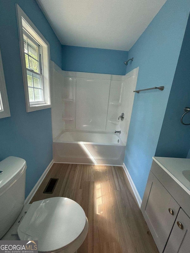 full bathroom with shower / washtub combination, hardwood / wood-style flooring, vanity, and toilet