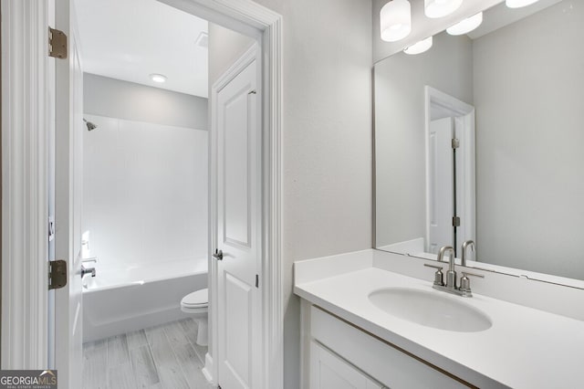 full bathroom with hardwood / wood-style flooring, toilet, vanity, and shower / bathtub combination