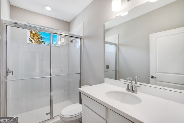 bathroom featuring vanity, toilet, and a shower with door