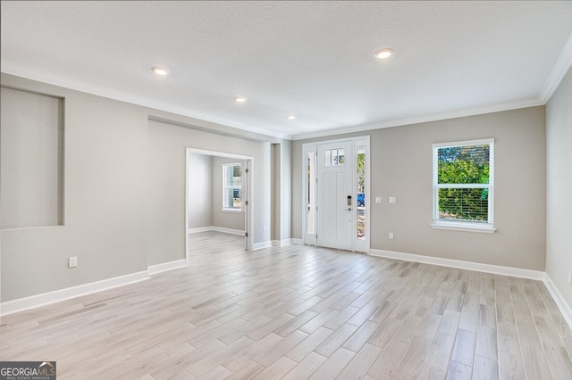 foyer featuring light hardwood / wood-style flooring and crown molding