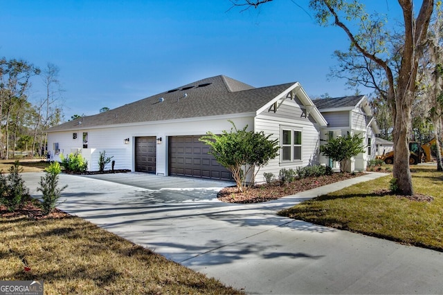 view of side of property with a garage and a lawn