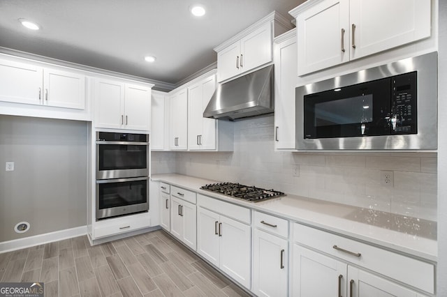 kitchen featuring white cabinetry, appliances with stainless steel finishes, and tasteful backsplash