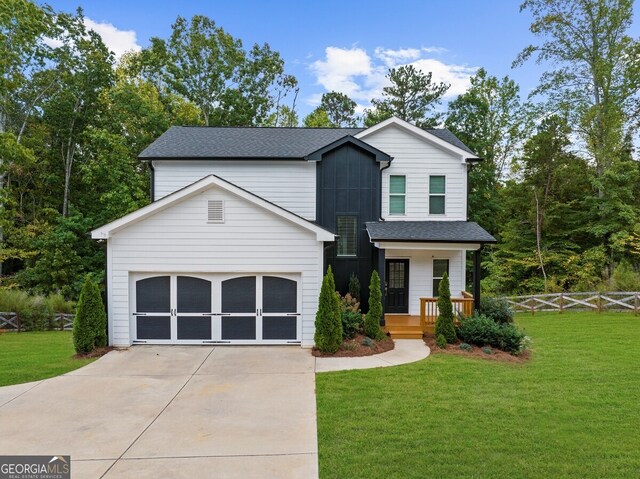 view of front of property with a porch, a garage, and a front yard