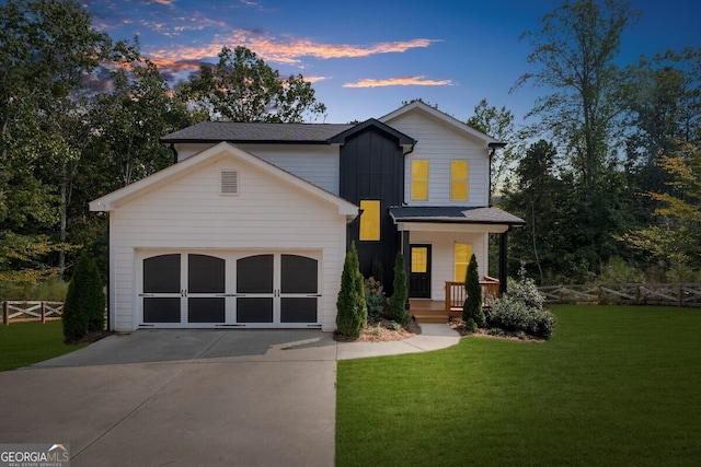 view of front of house with a yard, a porch, and a garage