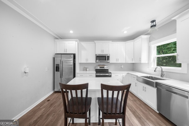 kitchen with white cabinets, appliances with stainless steel finishes, dark hardwood / wood-style floors, and sink