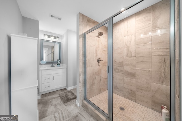 bathroom with a shower with shower door and vanity