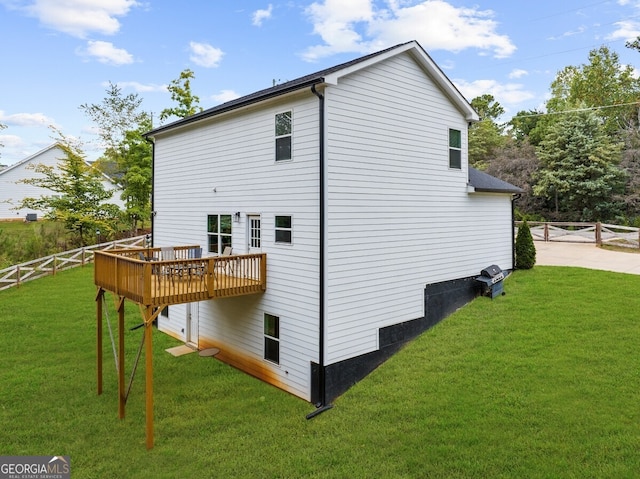 view of property exterior featuring a wooden deck and a lawn