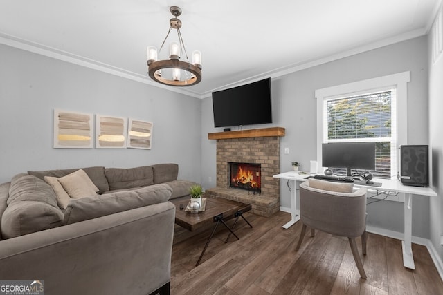 living room with a brick fireplace, a chandelier, hardwood / wood-style floors, and crown molding