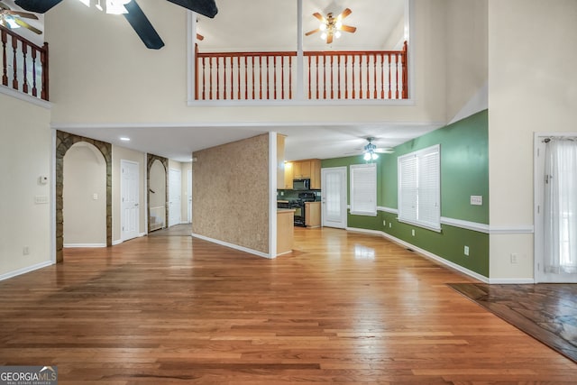 unfurnished living room with hardwood / wood-style flooring and a high ceiling