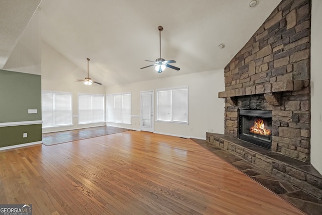 unfurnished living room with ceiling fan, hardwood / wood-style flooring, a fireplace, and high vaulted ceiling