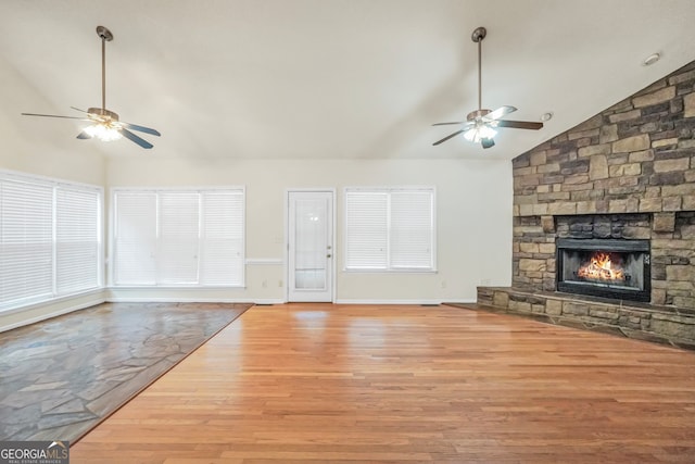 unfurnished living room featuring light hardwood / wood-style floors, a fireplace, ceiling fan, and high vaulted ceiling