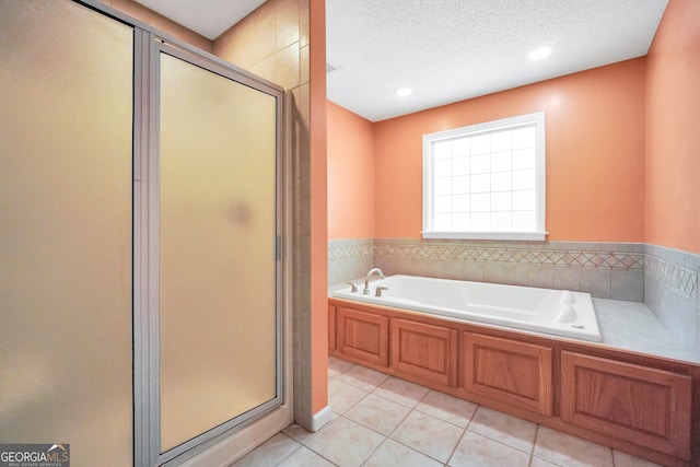 bathroom featuring shower with separate bathtub, a textured ceiling, and tile patterned floors