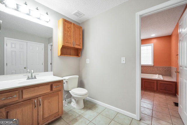 bathroom with vanity, a textured ceiling, a bathing tub, and toilet