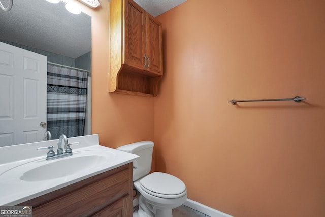 bathroom featuring a textured ceiling, vanity, and toilet