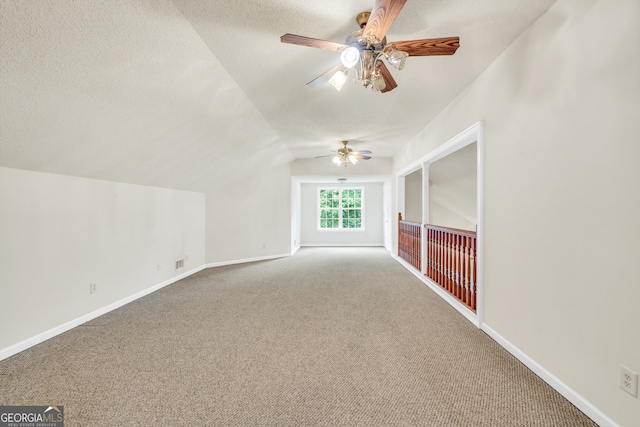 bonus room featuring ceiling fan, a textured ceiling, lofted ceiling, and carpet