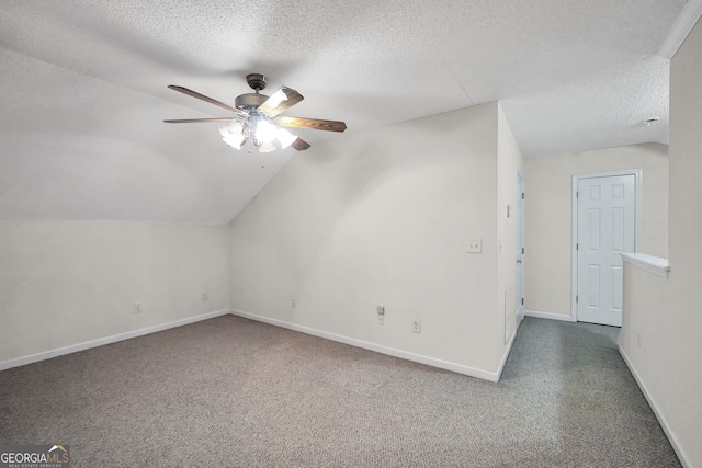 bonus room featuring a textured ceiling, lofted ceiling, dark colored carpet, and ceiling fan