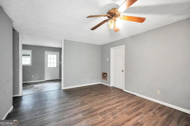 spare room with ceiling fan, a textured ceiling, and dark hardwood / wood-style flooring