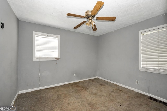 spare room featuring a textured ceiling, carpet, and ceiling fan