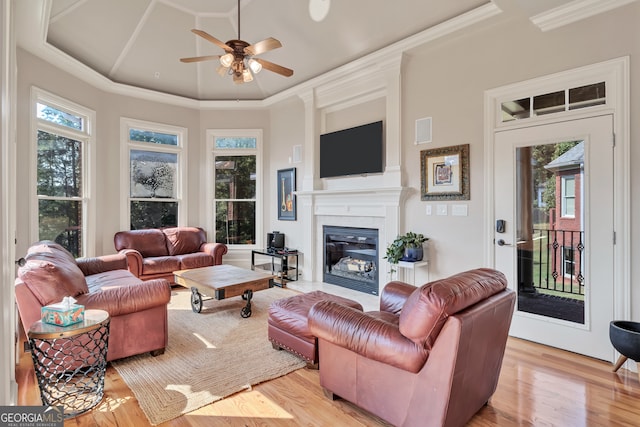 living room featuring ornamental molding, light wood-type flooring, and ceiling fan