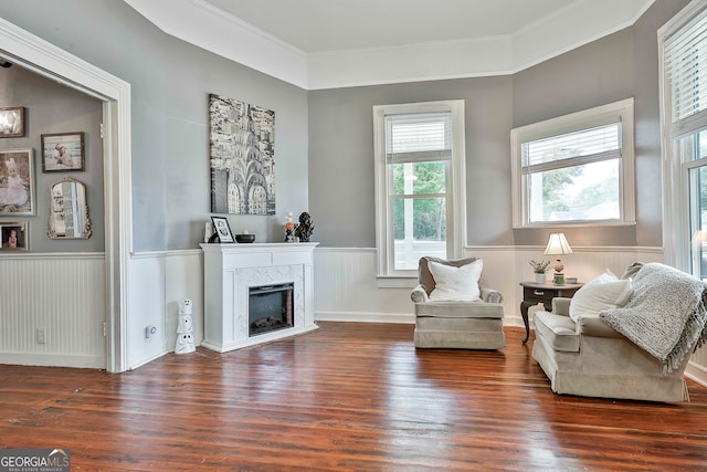 living area with crown molding and dark wood-type flooring